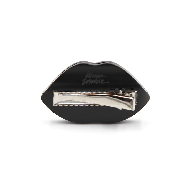 Barrette bouche en acrylique avec logo kiss me zombie gravé au laser vu de l'arrière avec la barrette crocodile en acier inox sur fond blanc