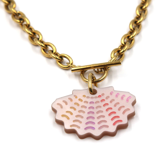 gros plan de collier grosse chaine forçat en acier inoxydable doré à l'or fin, avec un fermoir en T où se trouve une breloque coquille saint jacques en acrylique rose nacré et détails peints à la main sur fond blanc
