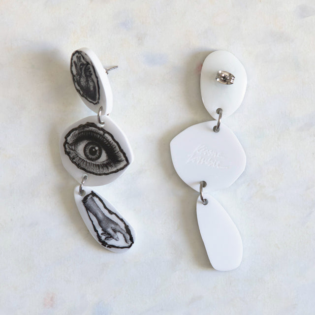 Verso des boucles d’oreilles DRAMARAMA cœur, œil et main en acrylique blanc avec clous en acier inoxydable