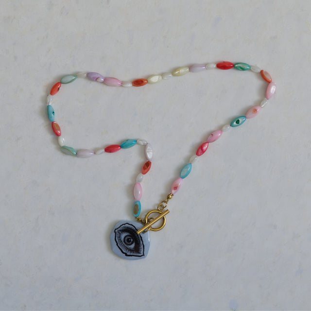 Vue entière du collier DRAMARAMA en perles de nacre multicolores avec pendentif œil
