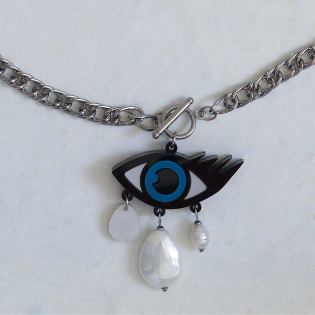 Détail du pendentif mauvais œil bleu et noir en acrylique avec perles et nacre