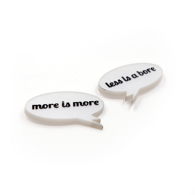 close up side view of More is more & less is a bore - Laser cut acrylic speech bubble pin brooches on a white background