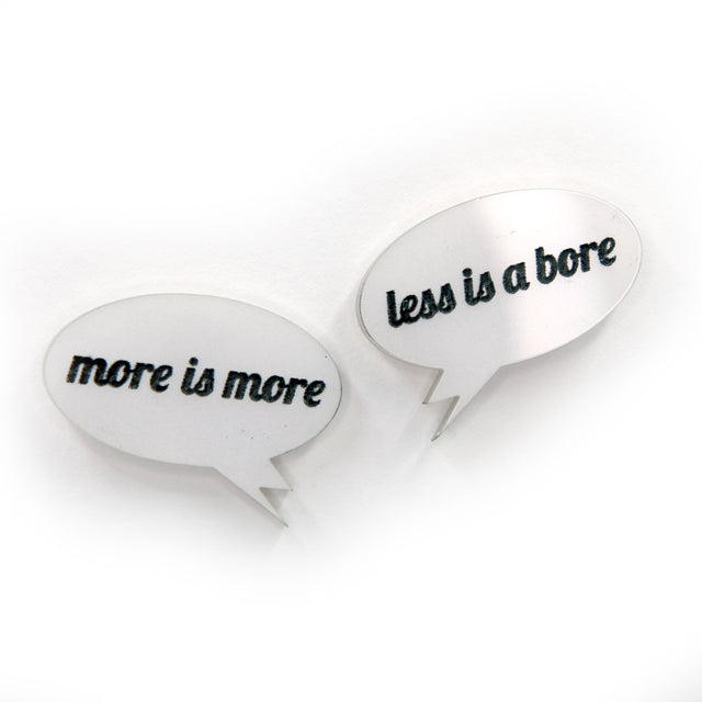 close up More is more & less is a bore - Laser cut acrylic speech bubble pin brooches on a white background