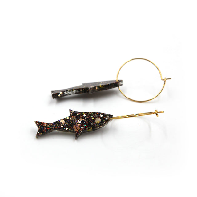 close up side view of gold glitter fish gold plated hoop earrings on a white background