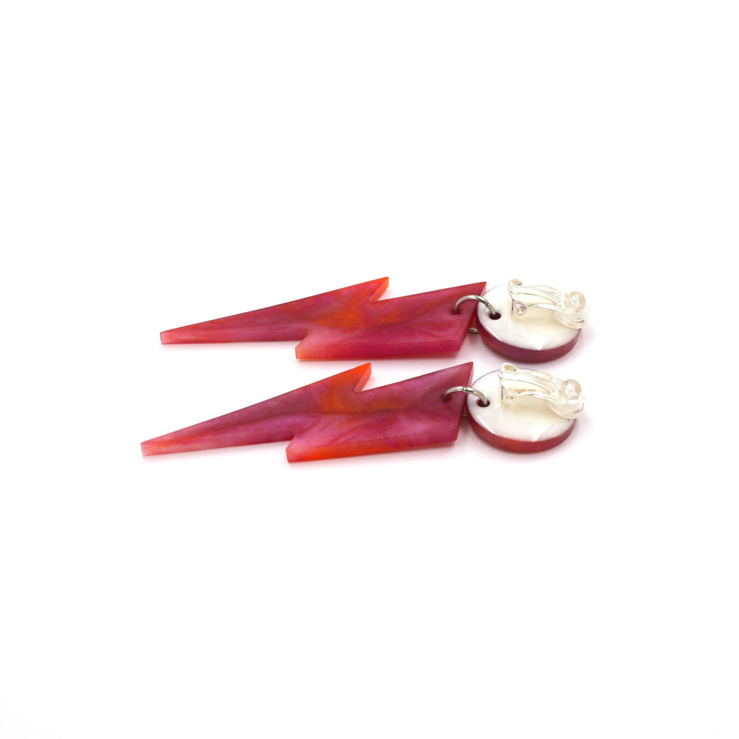 this is a picture of pink and orange marbled bolt and dot dangle earrings on a white background. one is on the back, the clip on are silver on a white dot.