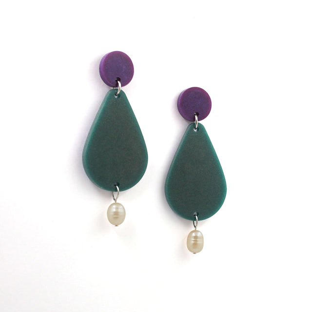 picture of earrings on a white background. the earrings are composed by a purple dot at the top, then a bigger green pear shape and a freshwater pearls at the bottom hanging.