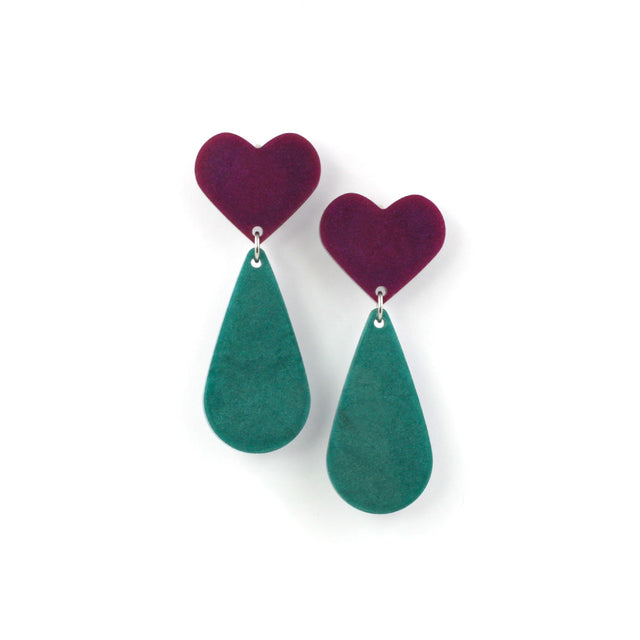 This is a picture of dangles earrings on a white background. The top of the earrings are purple heart and the pendants are green teardrop. 