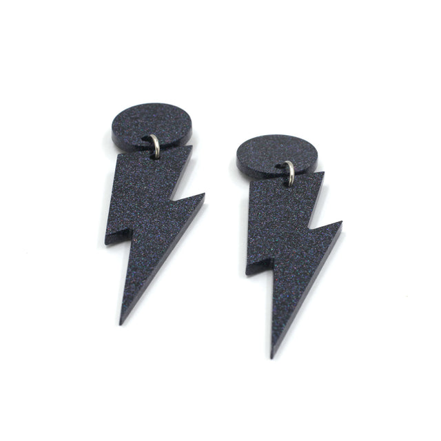 this is a picture of black holographic glitter bolt and dot dangle earrings on a white background.