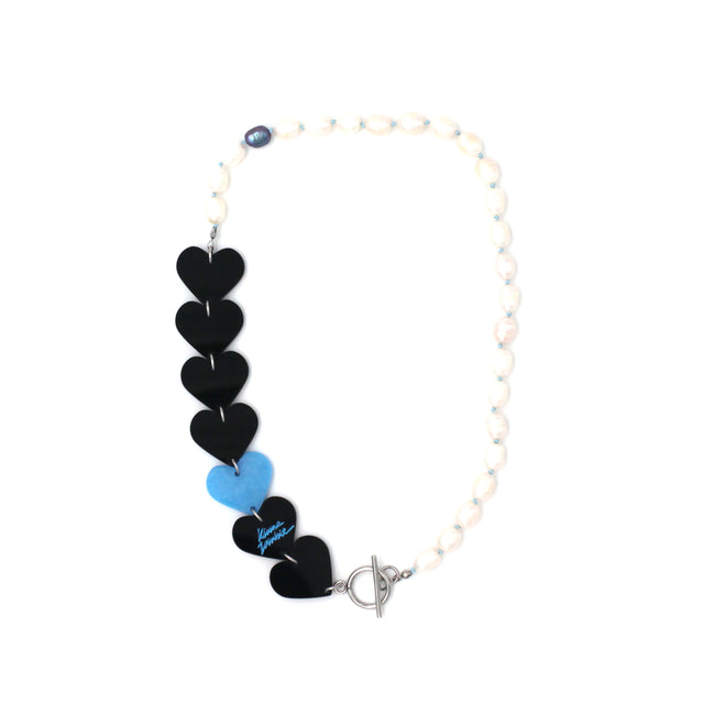 Laser-cut and resin black and blue hearts necklace with freshwater pearls and toggle clasp on a white background.