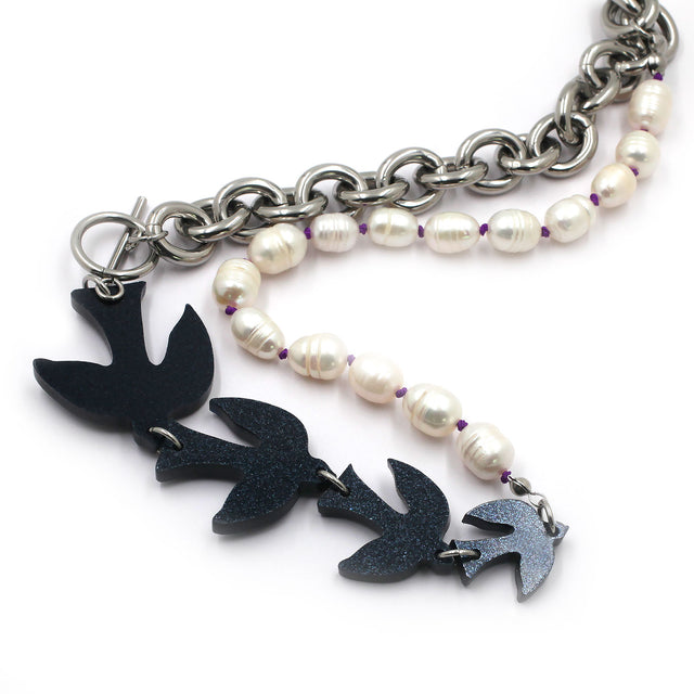 this is black glitter birds with pearls and chunky chain necklace on a white background.