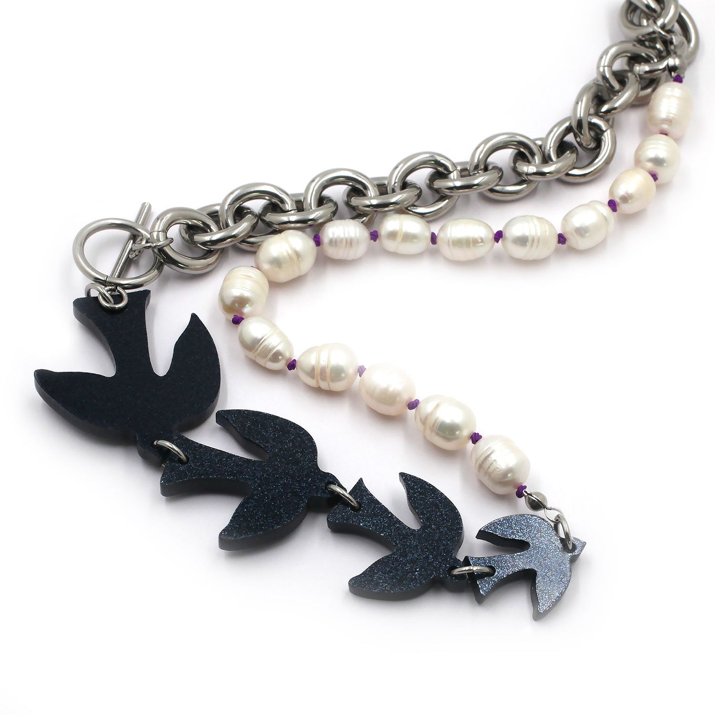 this is black glitter birds with pearls and chunky chain necklace on a white background. 