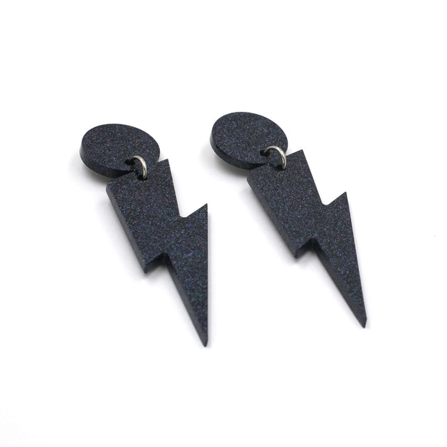 this is a picture of black holographic glitter bolt and dot dangle earrings on a white background.