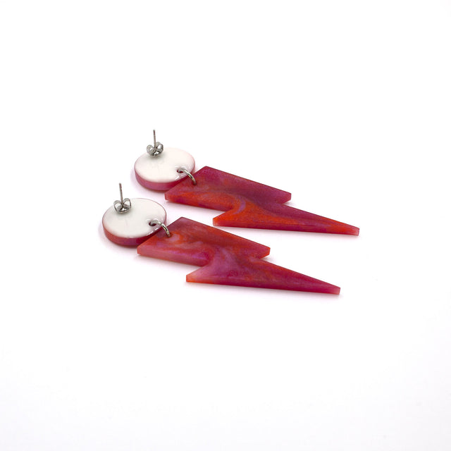 this is a picture of pink and orange marbled bolt and dot dangle earrings on a white background. one is on the back, the stud are silver on a white dot.