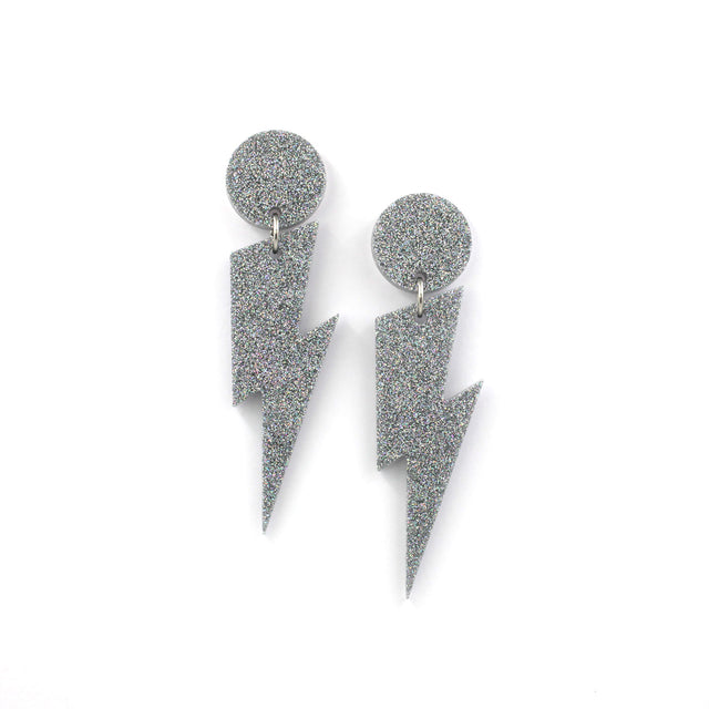 this is a picture of silver holographic glitter bolt and dot dangle earrings on a white background.