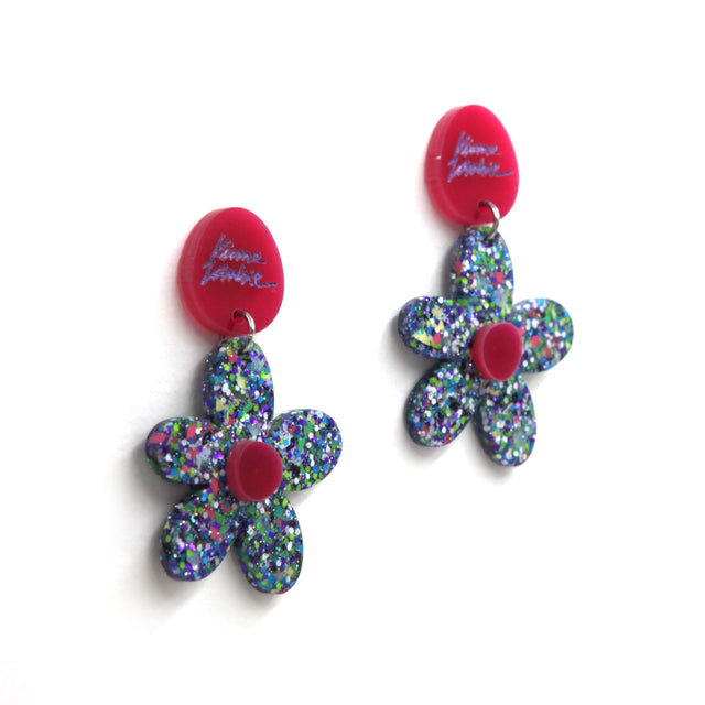 other side view of blue resin confetti flowers with round pink laser-cut clip-on earrings on a white background