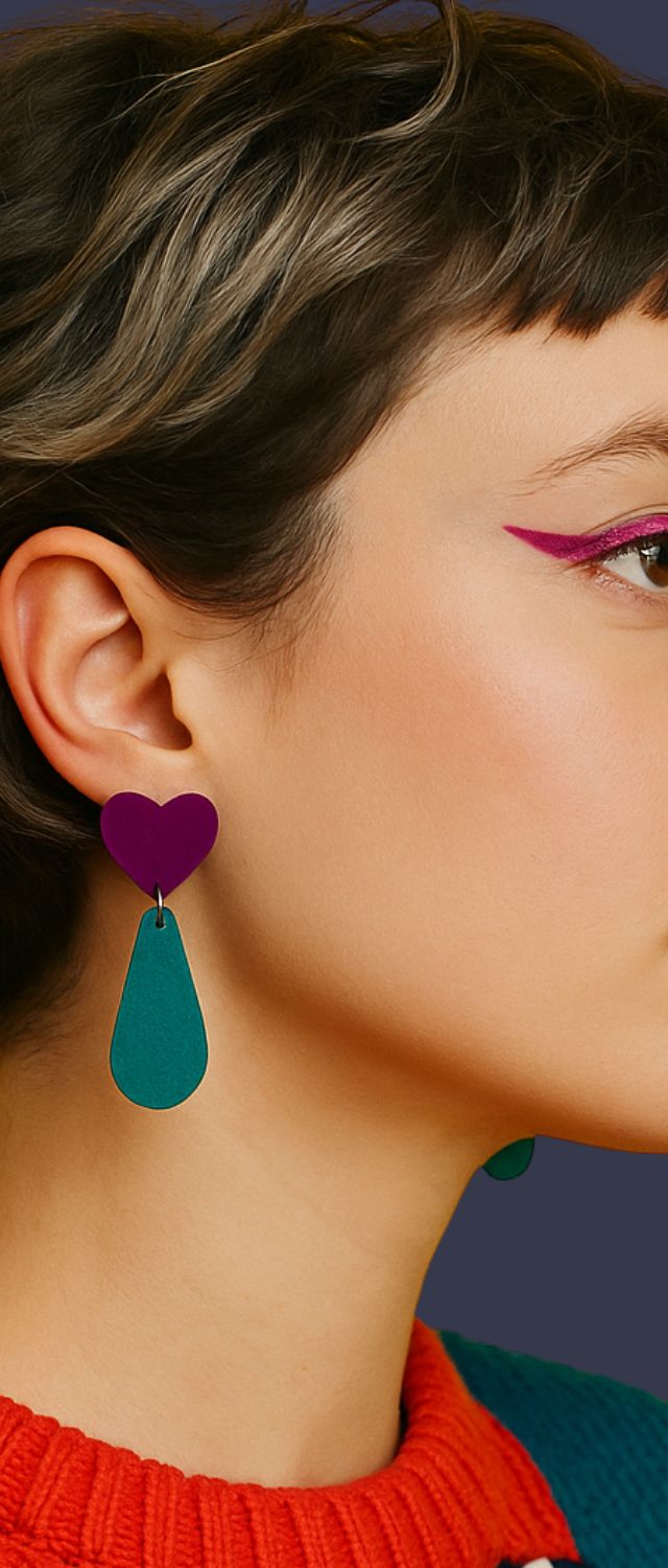 Portrait rapproché d’une femme au liner rose vif avec boucle d’oreille cœur et goutte colorée, bijou statement fait main à Marseille par Kiss Me Zombie.