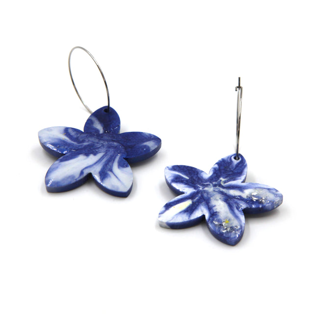 back of the blue marbled resin with hand painted details flower hoop earrings on a white background