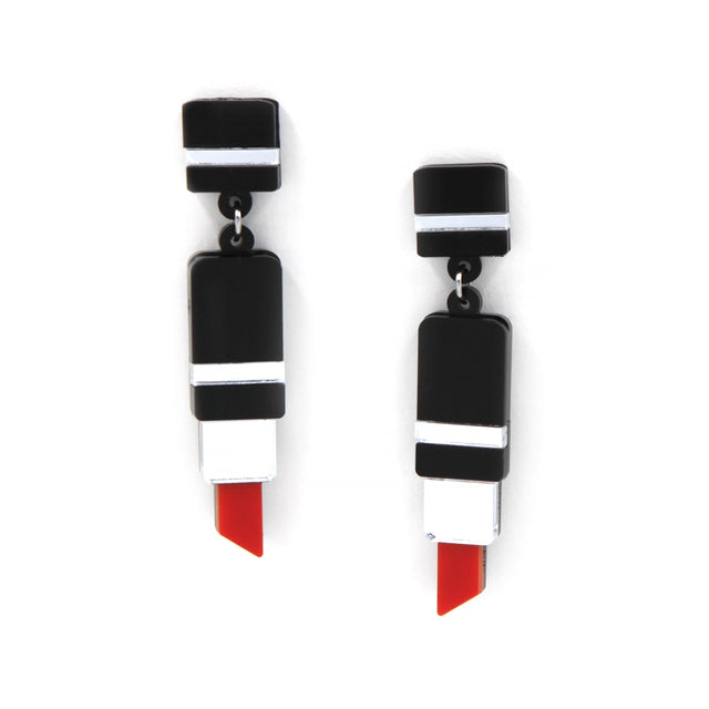 vue rapprochée sur boucles d'oreilles en forme de tube de rouge à lèvre en acrylique noir, rouge et miroir argenté découpé au laser sur fond blanc