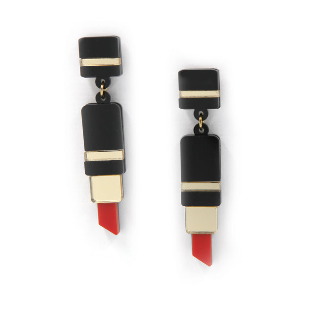 vue rapprochée de boucles d'oreilles en forme de tube de rouge à lèvre en acrylique noir, rouge et miroir doré découpé au laser sur fond blanc