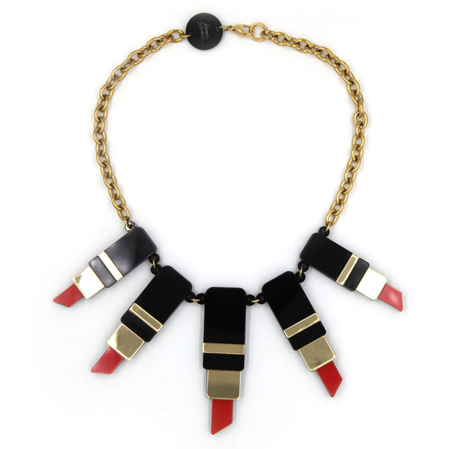 autre vu du dessus d'un collier plastron composé de tube de rouge à lèvre en acrylique noir, rouge et miroir doré avec une grosse chaîne en acier doré à l'or fin sur fond blanc