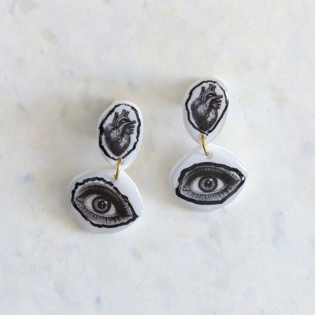 Boucles d’oreilles DRAMARAMA avec cœur anatomique et œil noir et blanc sur acrylique blanc