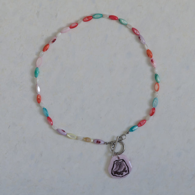 Collier DRAMARAMA en nacre colorée et blanche avec pendentif patins à roulettes rose