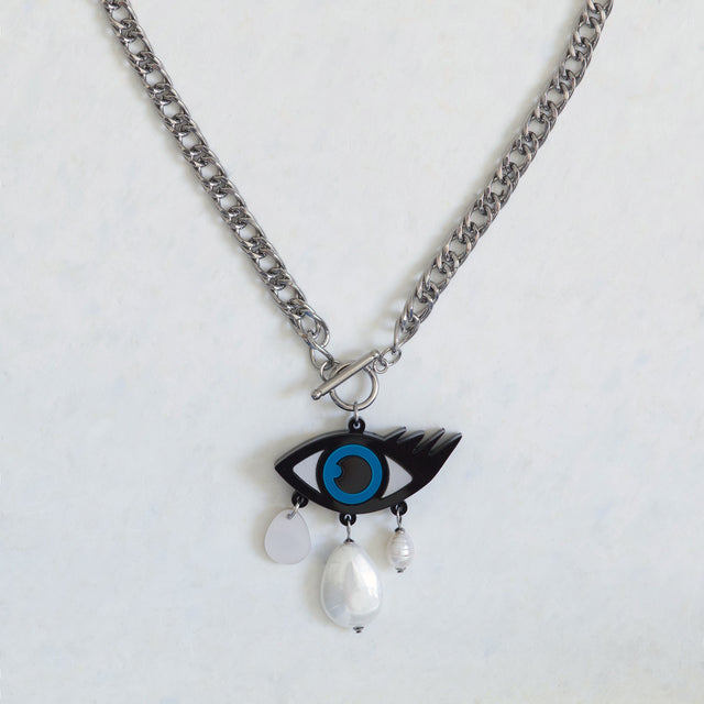 Détail du pendentif mauvais œil bleu et noir en acrylique avec perles et nacre