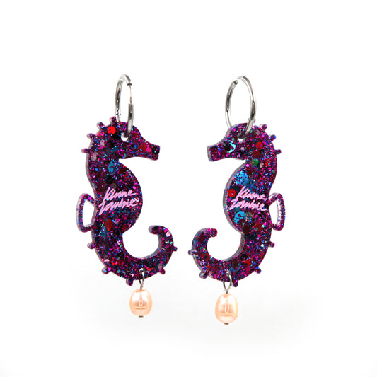 pink glitter resin sea horse hoop earrings with freshwater pearls on a white background