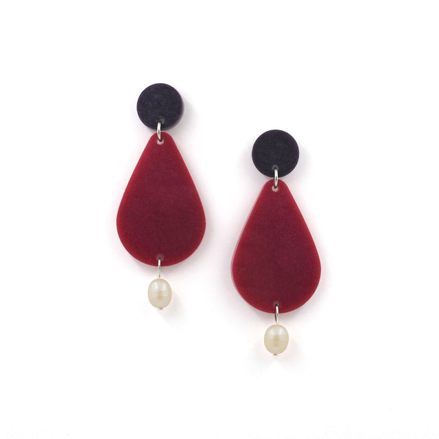 picture of earrings on a white background. the earrings are composed by a purple dot at the top, then a bigger dark pink pear shape and a freshwater pearls at the bottom hanging.