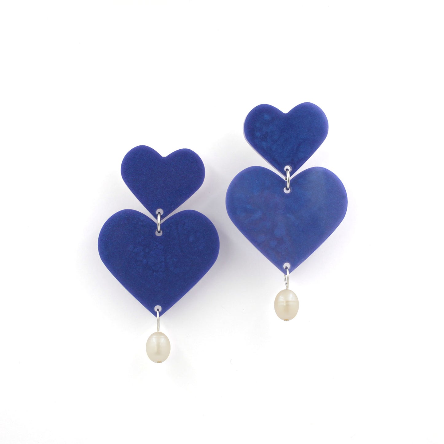 This is a picture of blue hearts earrings with freshwater pearls on a white background.