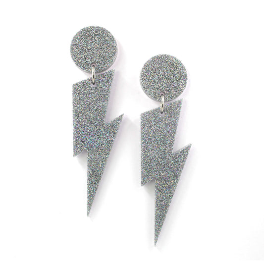 this is a picture of silver holographic glitter bolt and dot dangle earrings on a white background. 