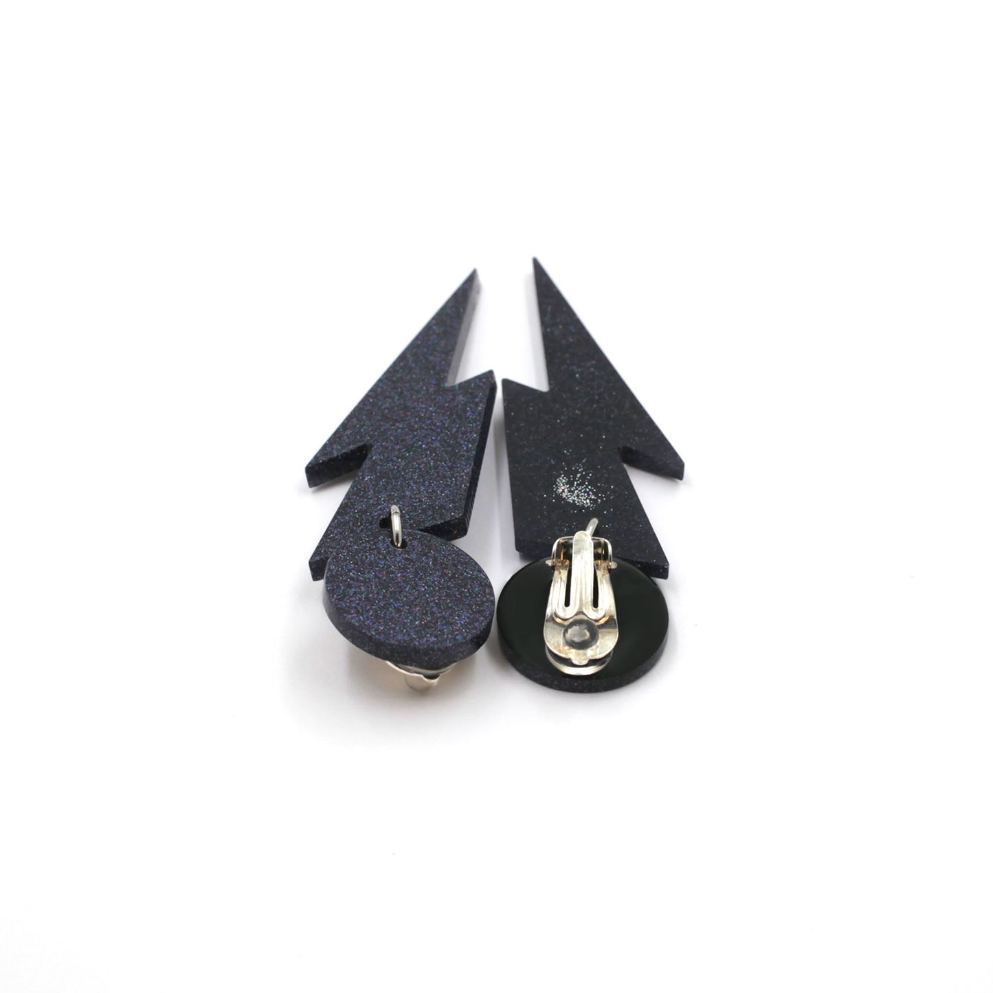 this is a picture of black holographic glitter bolt and dot dangle earrings on a white background. one is on the back, the clip on are silver on a black dot.