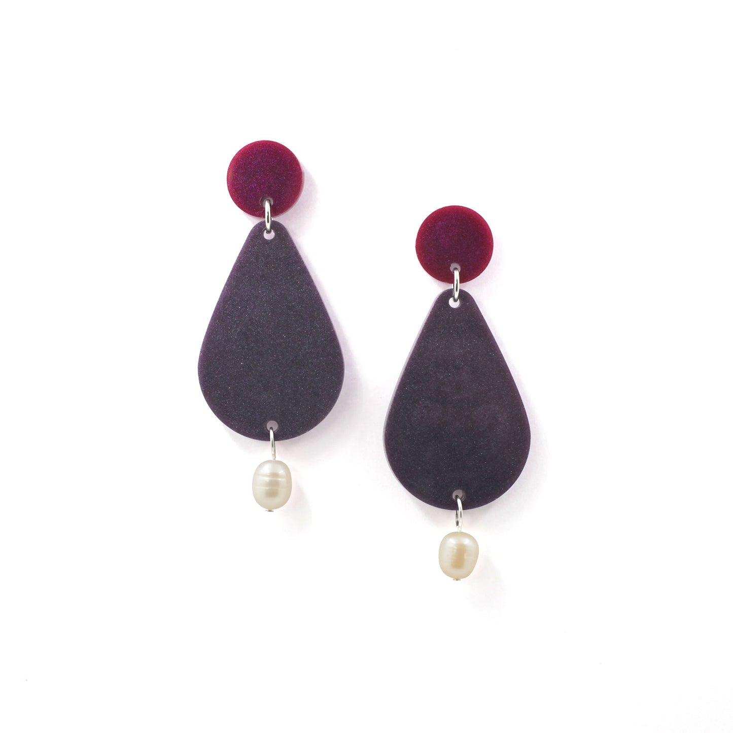 picture of earrings on a white background. the earrings are composed by a pink dot at the top, then a bigger purple pear shape and a freshwater pearls at the bottom hanging. 