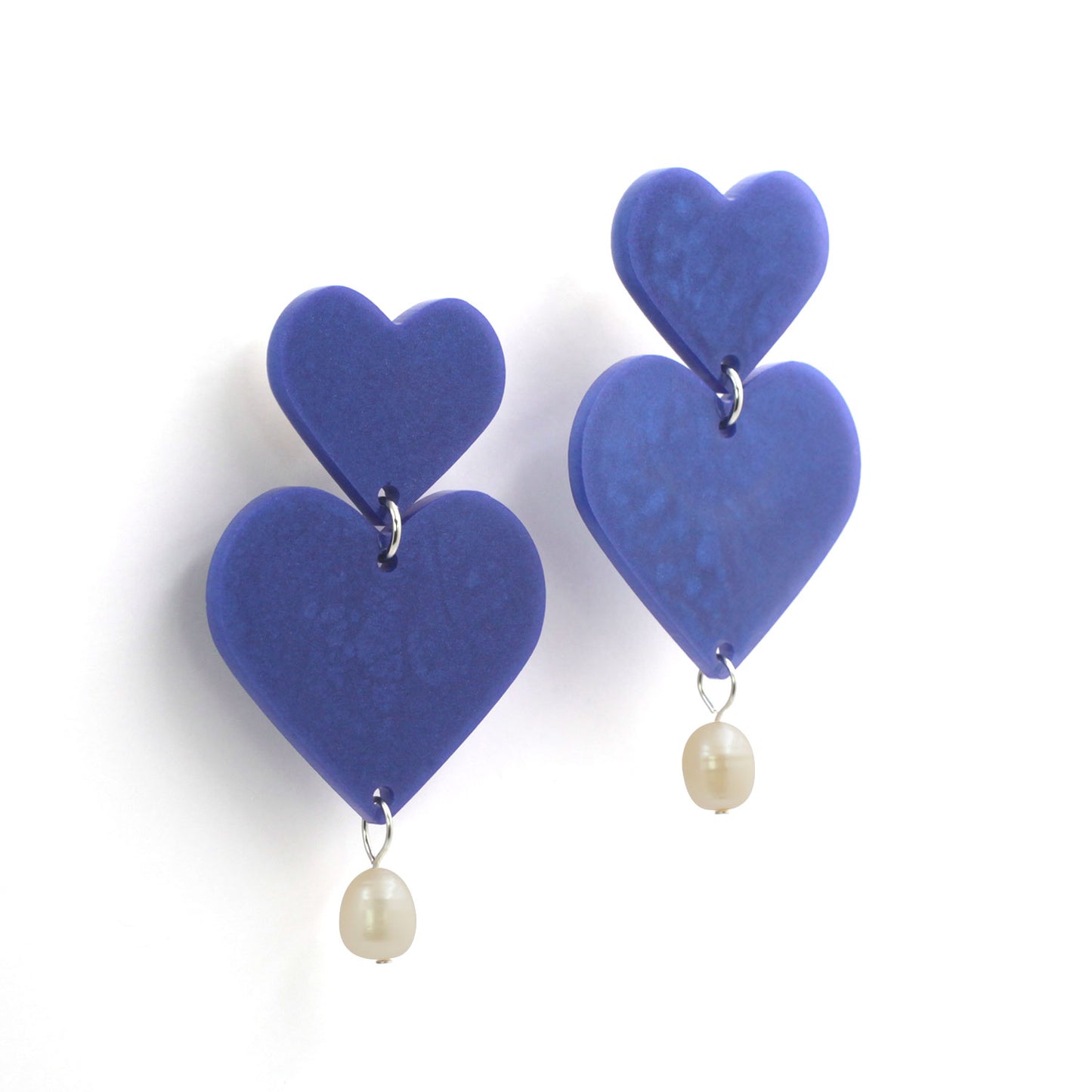 This is a picture of purple hearts earrings with freshwater pearls on a white background.
