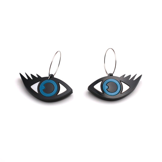 on a white background, a pair of black, white and blue laser cut acrylic evil eye hoops earrings